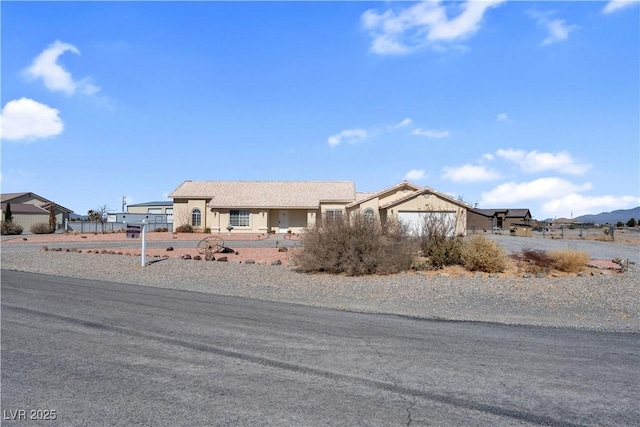 view of front of property featuring an attached garage and fence