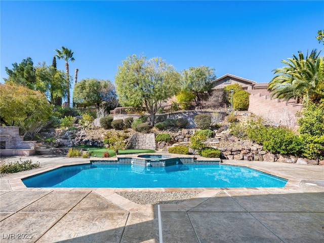 view of swimming pool with a patio area and a pool with connected hot tub