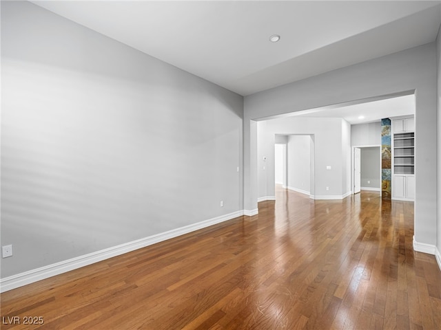 unfurnished room with hardwood / wood-style flooring and baseboards