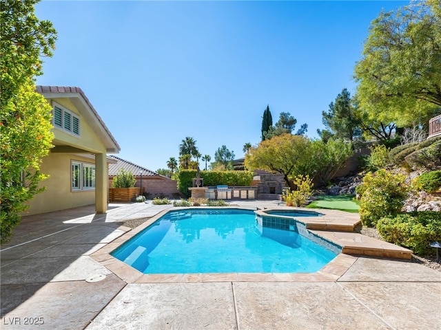 view of swimming pool featuring a patio, fence, and a pool with connected hot tub