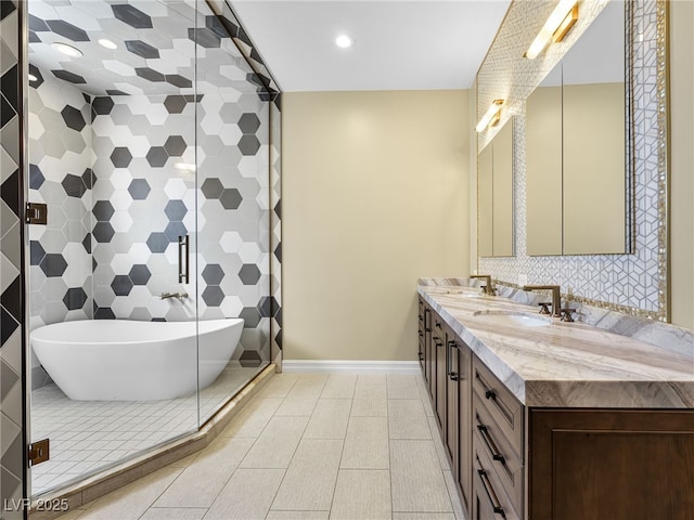 bathroom featuring double vanity, tile patterned flooring, a freestanding bath, a shower stall, and a sink