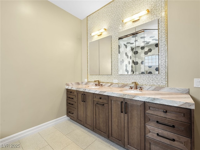 full bath featuring double vanity, tile patterned flooring, baseboards, and a sink