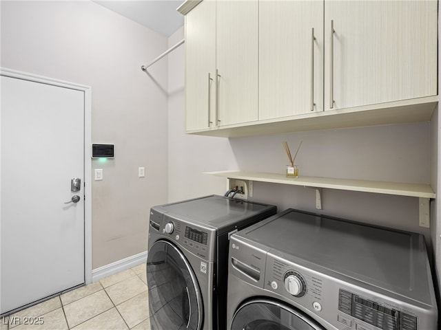 washroom with light tile patterned floors, independent washer and dryer, cabinet space, and baseboards