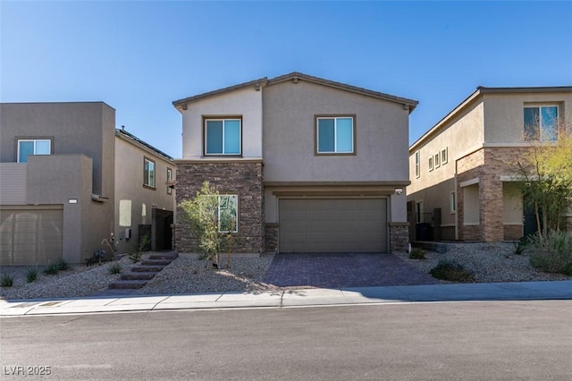 view of front of home featuring a garage, stone siding, decorative driveway, and stucco siding