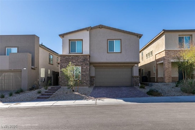 view of front facade featuring driveway, stucco siding, stone siding, and an attached garage