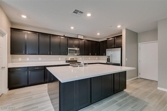 kitchen with wood finish floors, light countertops, visible vents, and stainless steel appliances