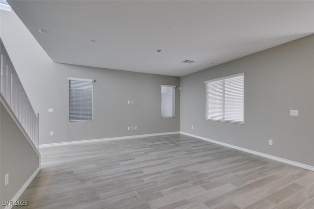 spare room with visible vents, light wood-style flooring, and baseboards
