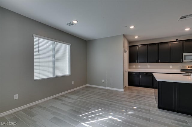 kitchen featuring visible vents, light countertops, light wood-style floors, and stainless steel appliances