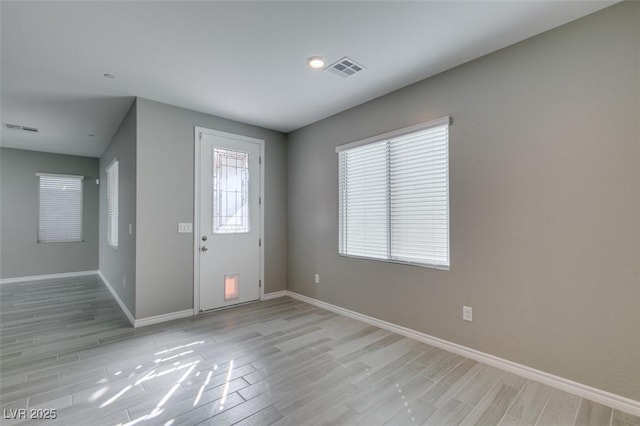 entryway with light wood-style floors, visible vents, and baseboards