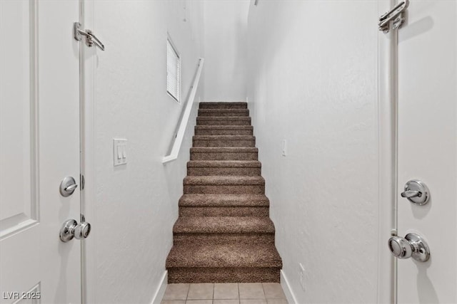 stairway featuring tile patterned flooring and baseboards