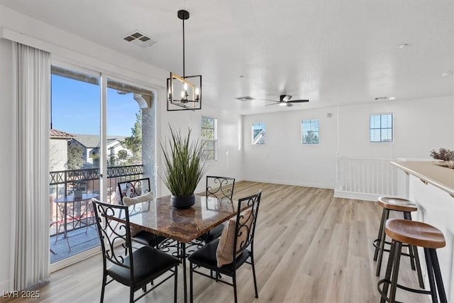 dining space featuring light wood-type flooring, a ceiling fan, visible vents, and a wealth of natural light