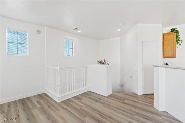 spare room featuring light wood-style floors, visible vents, baseboards, and recessed lighting