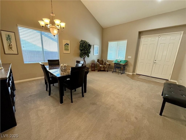 carpeted dining area featuring high vaulted ceiling, baseboards, and a chandelier