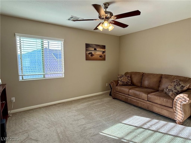 living area with a ceiling fan, carpet, and baseboards