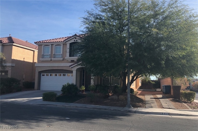 view of front of home featuring stucco siding, a garage, concrete driveway, and a tiled roof