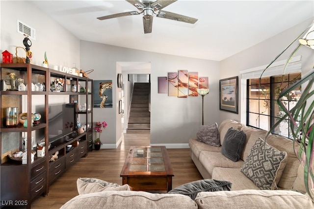 living area with visible vents, stairway, a ceiling fan, wood finished floors, and baseboards