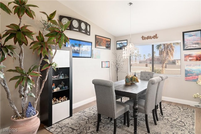 dining room with lofted ceiling, baseboards, and wood finished floors