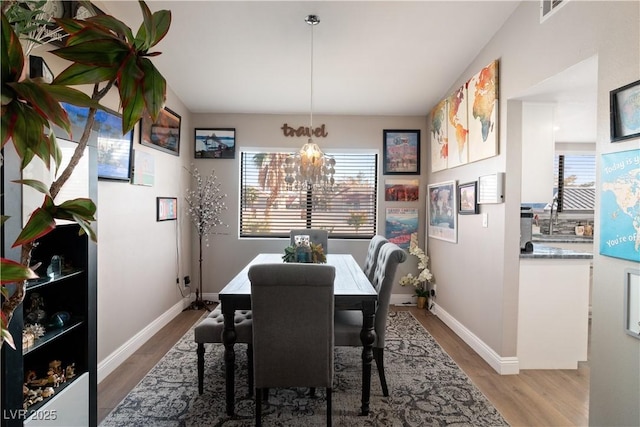 dining space featuring a healthy amount of sunlight, visible vents, and wood finished floors