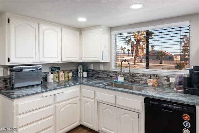 kitchen featuring decorative backsplash, white cabinets, dishwasher, and a sink