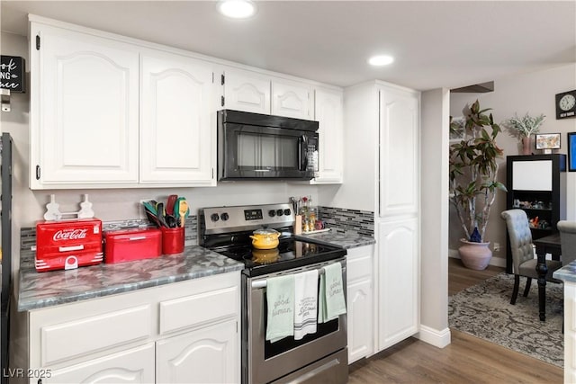 kitchen featuring stainless steel range with electric stovetop, black microwave, white cabinets, and dark wood finished floors