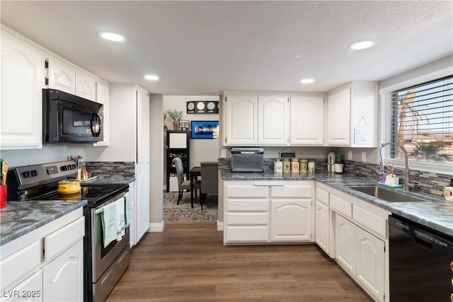 kitchen with black appliances, dark wood-style flooring, a sink, and white cabinets