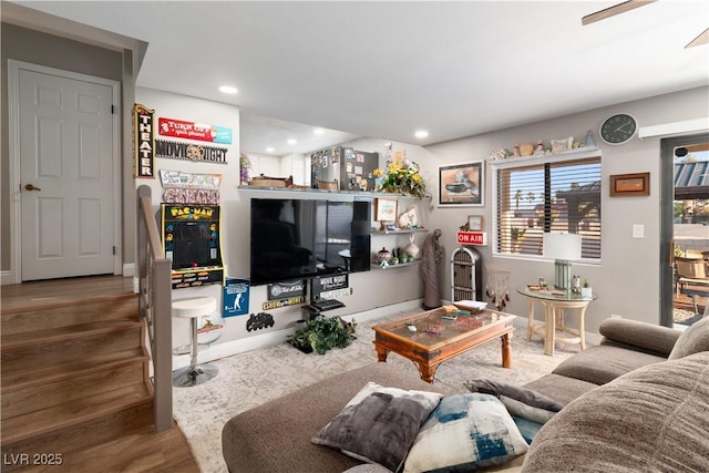 living room featuring stairs, baseboards, wood finished floors, and recessed lighting