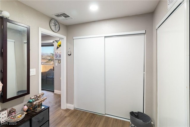 corridor with wood finished floors and visible vents