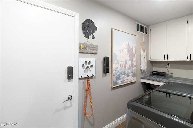 laundry room featuring cabinet space, baseboards, visible vents, and washing machine and dryer