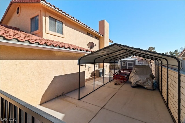 view of patio with central AC unit and a carport