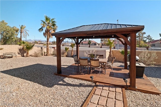 exterior space with outdoor dining space, a fenced backyard, a wooden deck, and a gazebo