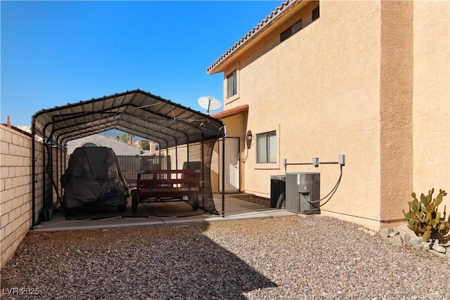 exterior space with a carport, fence, and central air condition unit