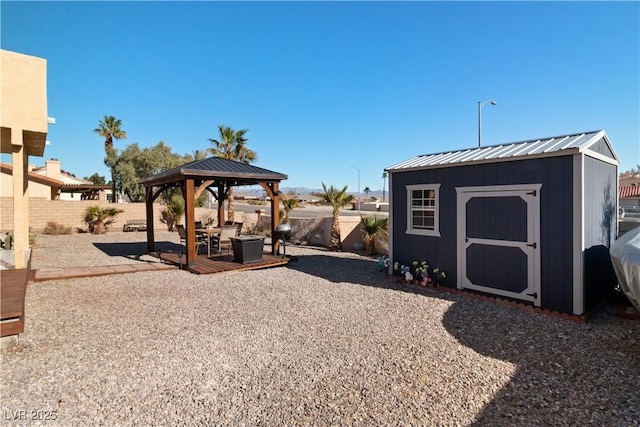 exterior space featuring an outbuilding, a fenced backyard, a gazebo, and a storage unit