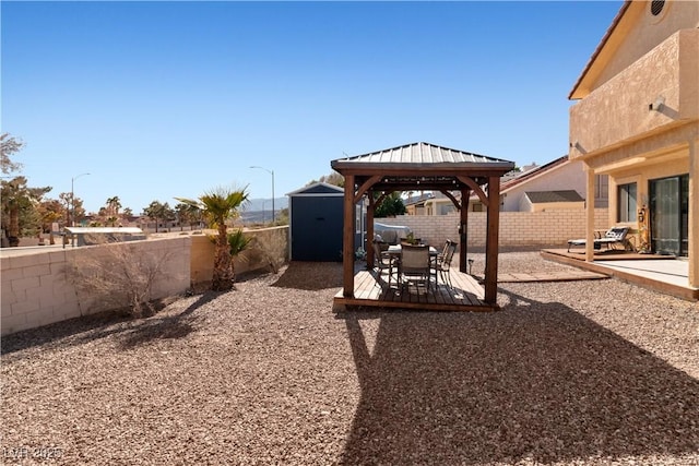 view of yard featuring an outbuilding, a patio, a fenced backyard, a gazebo, and a storage unit