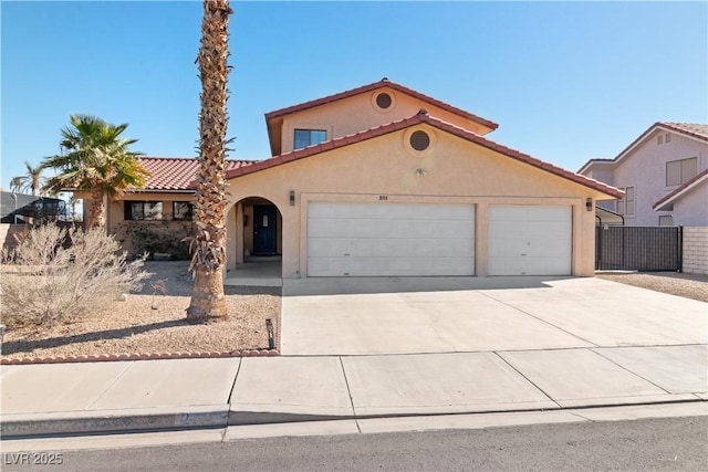 mediterranean / spanish house featuring driveway, a tiled roof, an attached garage, fence, and stucco siding