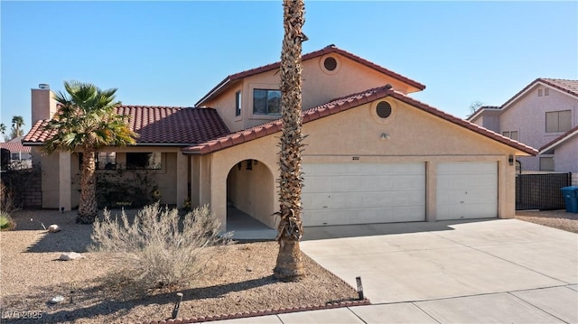 mediterranean / spanish home with a tile roof, a chimney, stucco siding, concrete driveway, and an attached garage