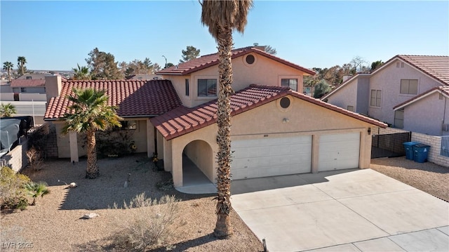 mediterranean / spanish home with a tile roof, stucco siding, an attached garage, fence, and driveway