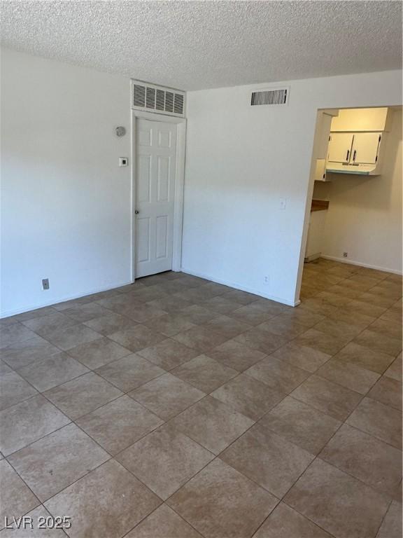 empty room featuring visible vents and a textured ceiling