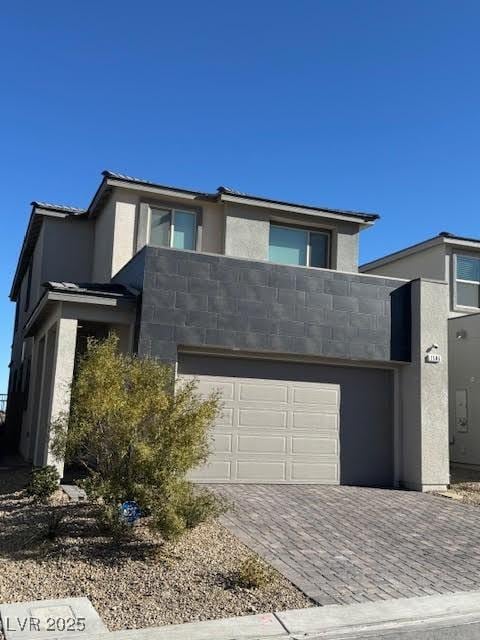 view of front of property with a garage, decorative driveway, and stucco siding