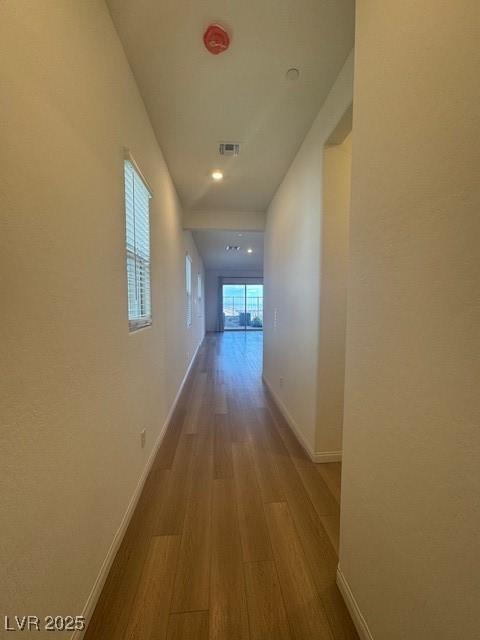 corridor with visible vents, baseboards, and wood finished floors