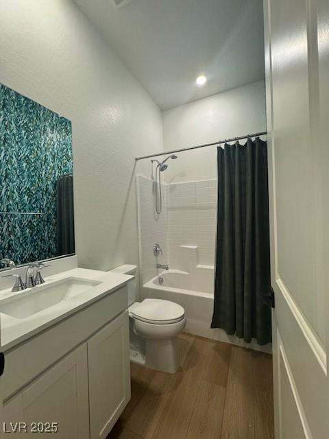 full bathroom featuring toilet, shower / bath combo with shower curtain, wood finished floors, and vanity