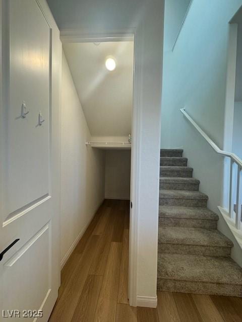 stairway with lofted ceiling and wood finished floors