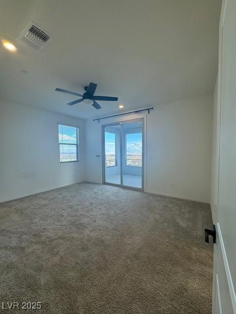 spare room with ceiling fan, carpet flooring, and visible vents