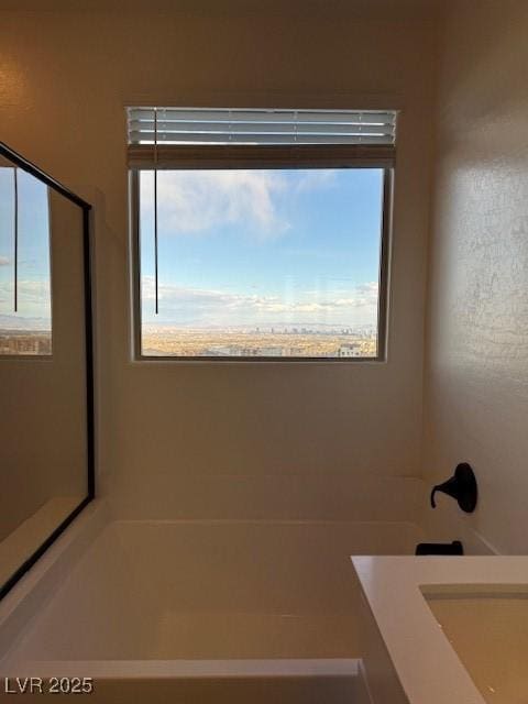 full bath featuring a tub to relax in and plenty of natural light