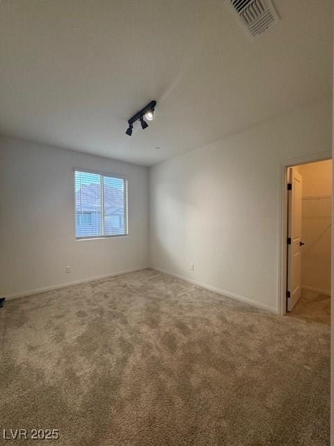 unfurnished room with rail lighting, visible vents, and carpet flooring