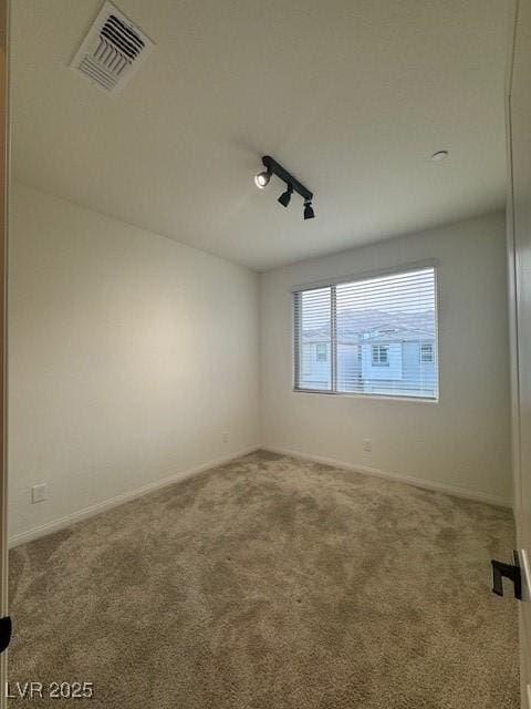 spare room featuring baseboards, visible vents, and carpet flooring