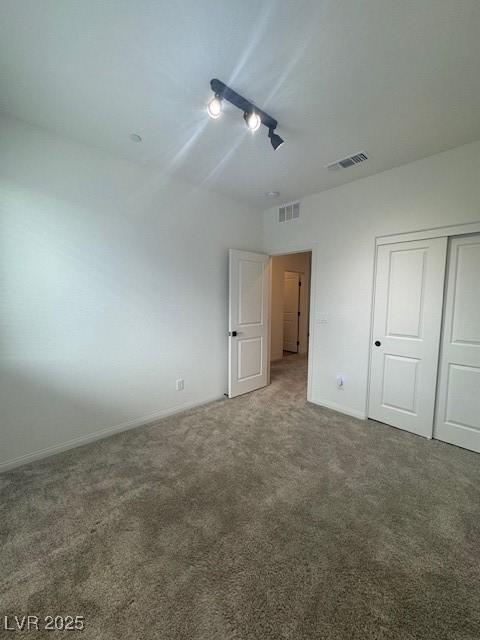 unfurnished bedroom featuring carpet, a closet, visible vents, and baseboards