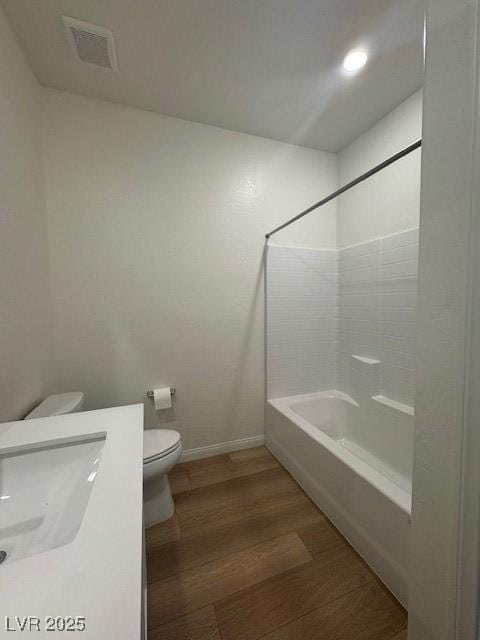 full bathroom featuring toilet, wood finished floors, vanity, visible vents, and baseboards