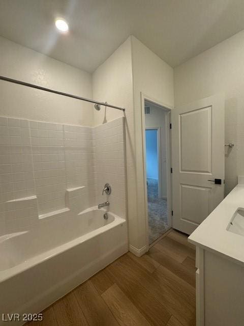 full bath with vanity, wood finished floors, and shower / tub combination