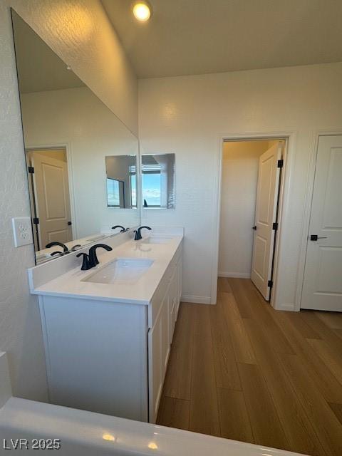 bathroom featuring wood finished floors, vanity, and baseboards