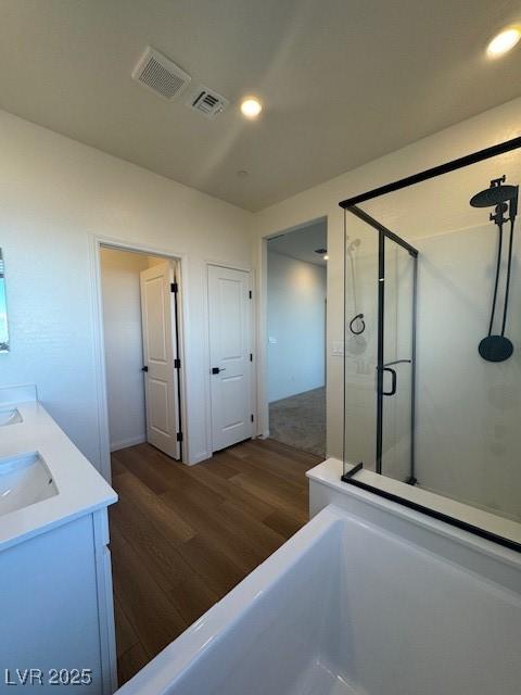 full bathroom featuring a shower stall, visible vents, wood finished floors, and recessed lighting